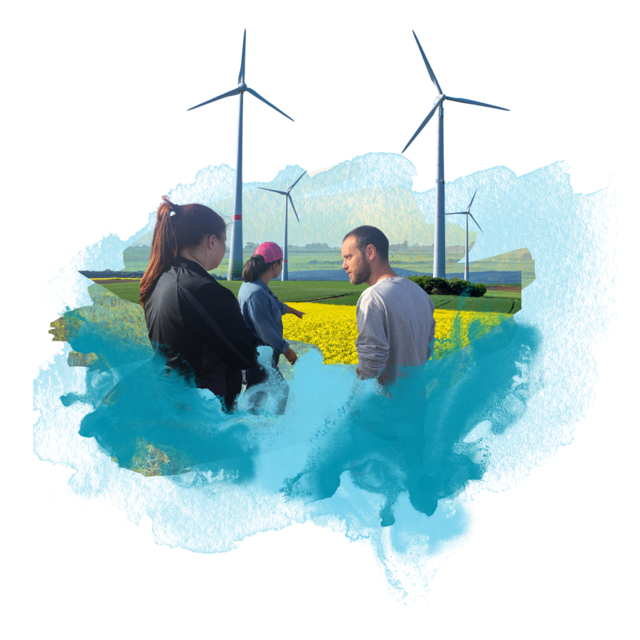 people standing in a field with windmills in the background