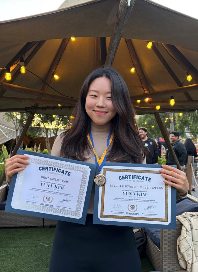 Yuna Kim holding up two certificates