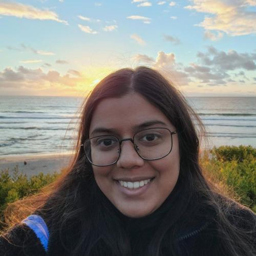 woman smiling in front of a sunset