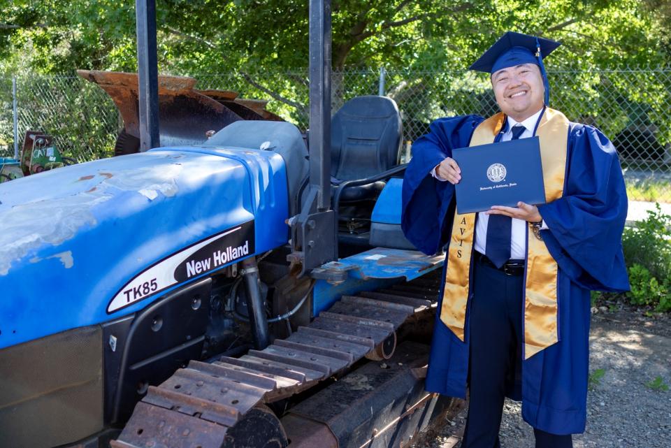 Michael Hui holding his diploma