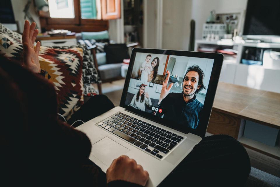 A person in a virtual meeting with their laptop on their lap